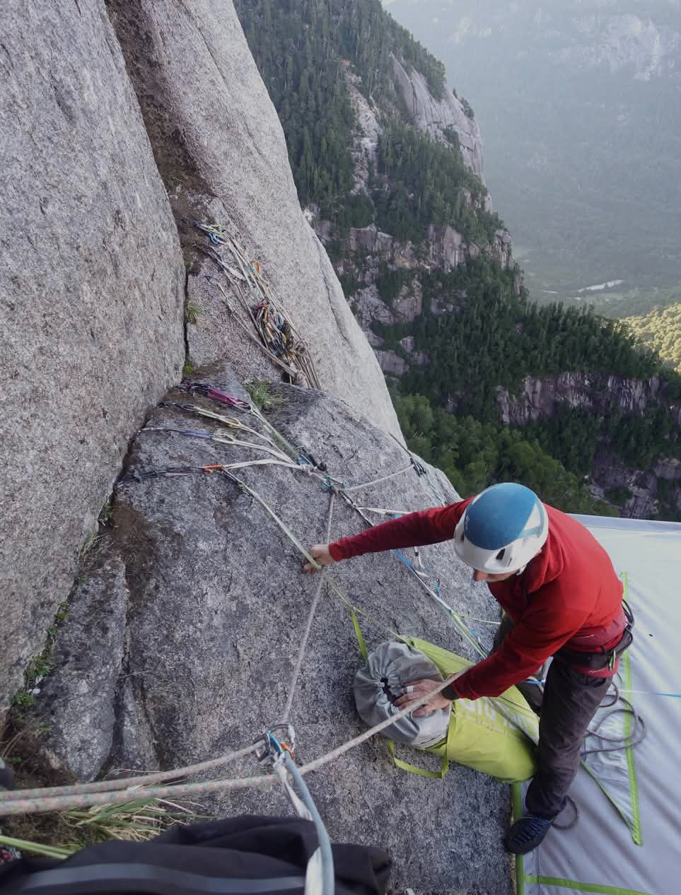 A climber examines the anchor nest above their portaledge.