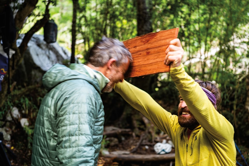  One person eggs on another person to try and break a board with their forehead.