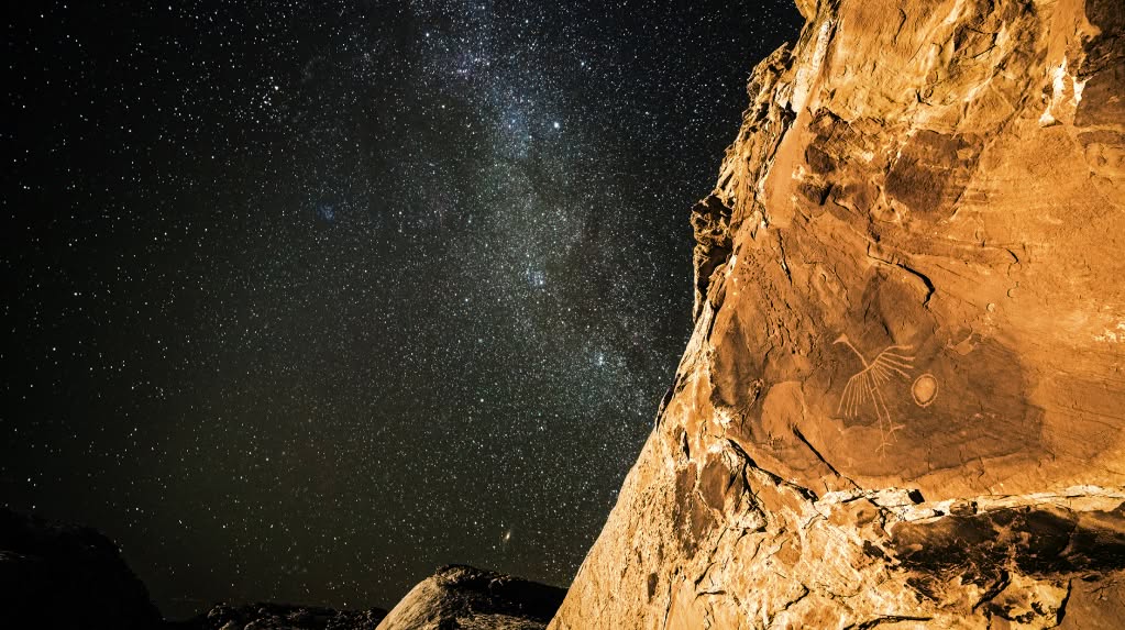 Half the frame is desert sandstone, the other half is a night sky with the Milky Way running through it.
