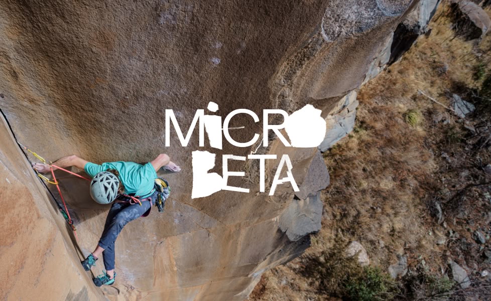 A person climbs a rock as seen from above.