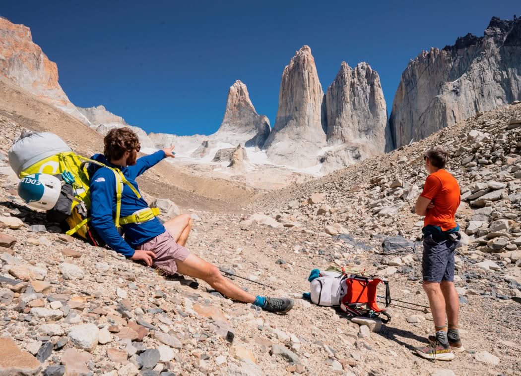 Two climbers on the approach talk about their objective in the distance.