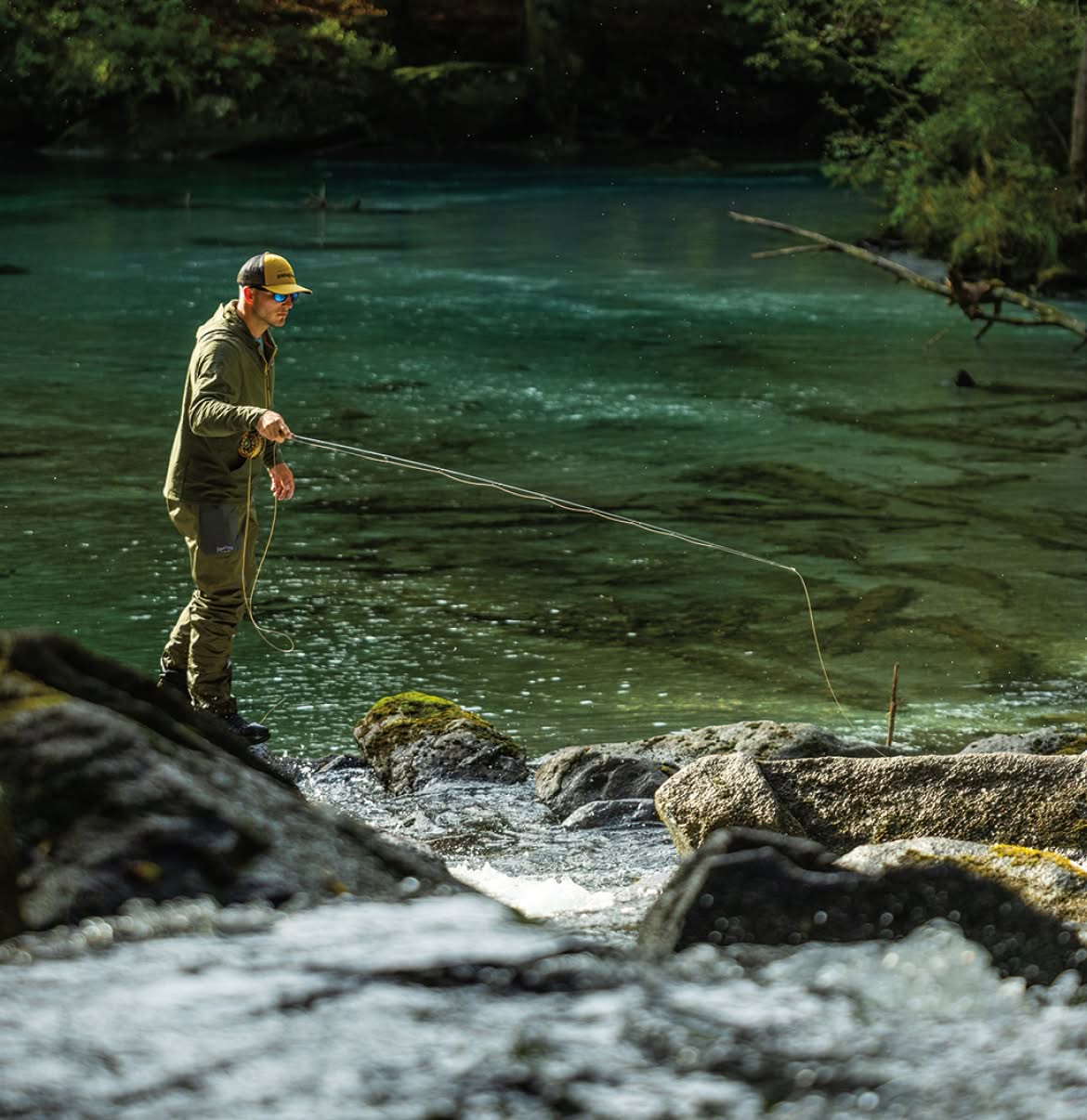 An angler makes a cast to a rocky river pool.