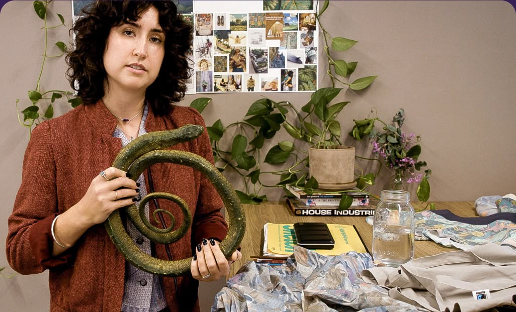 A person holding a rubber snake.