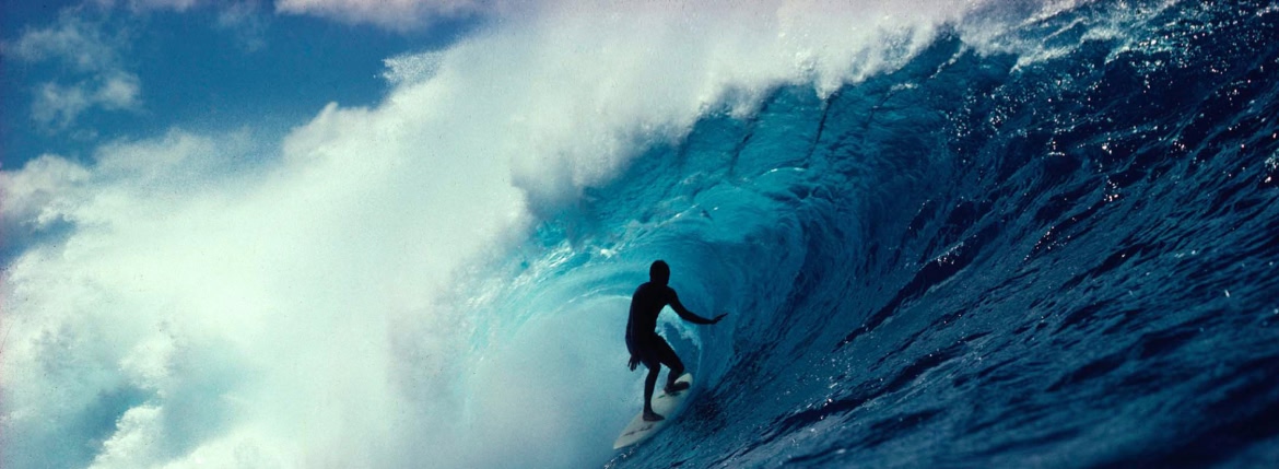A surfer in the tube of a wave.