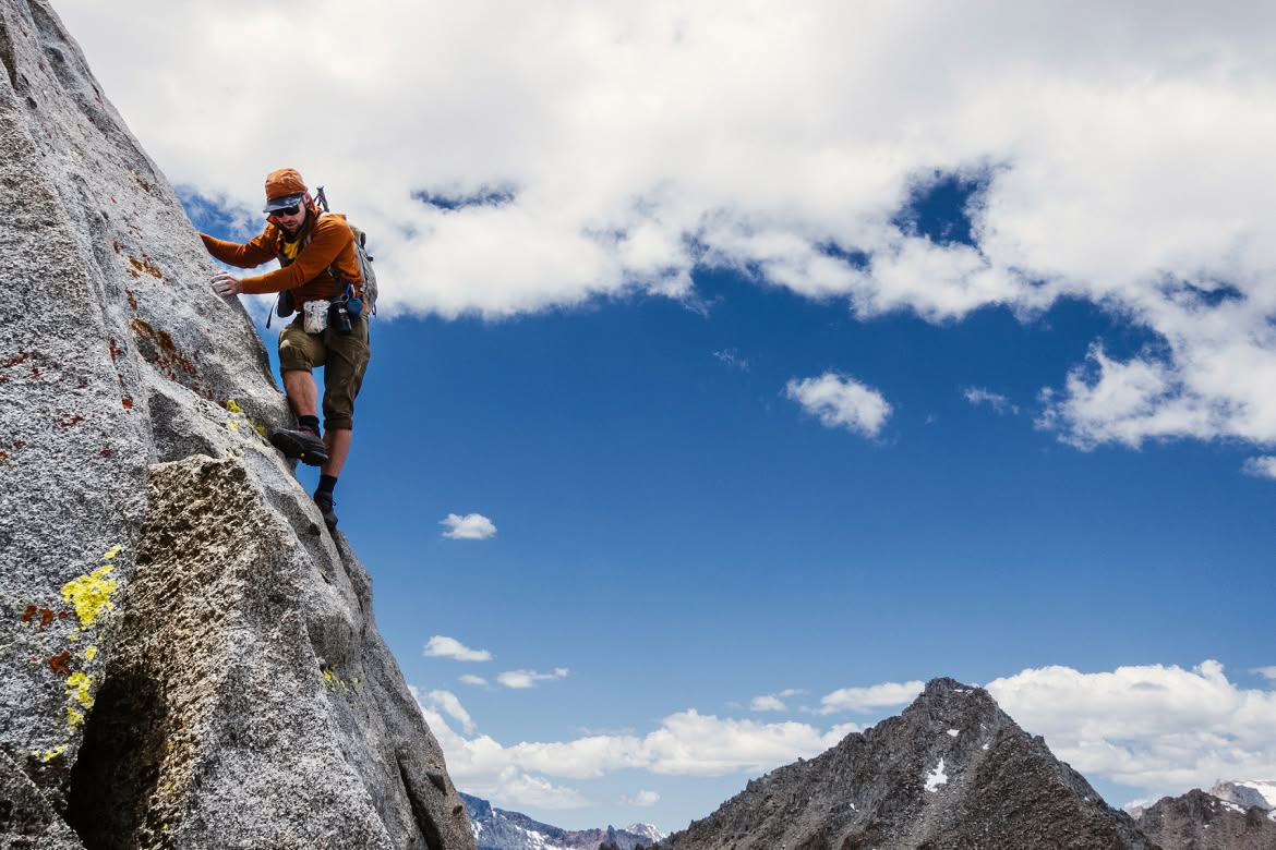 A person hike climbs on granite.
