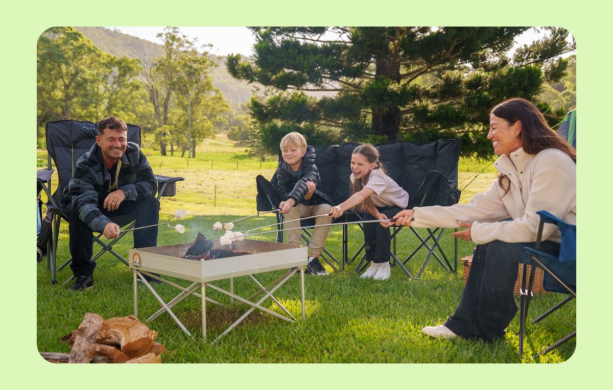 Family roasting marshmallows around a campfire — BCF autumn offer