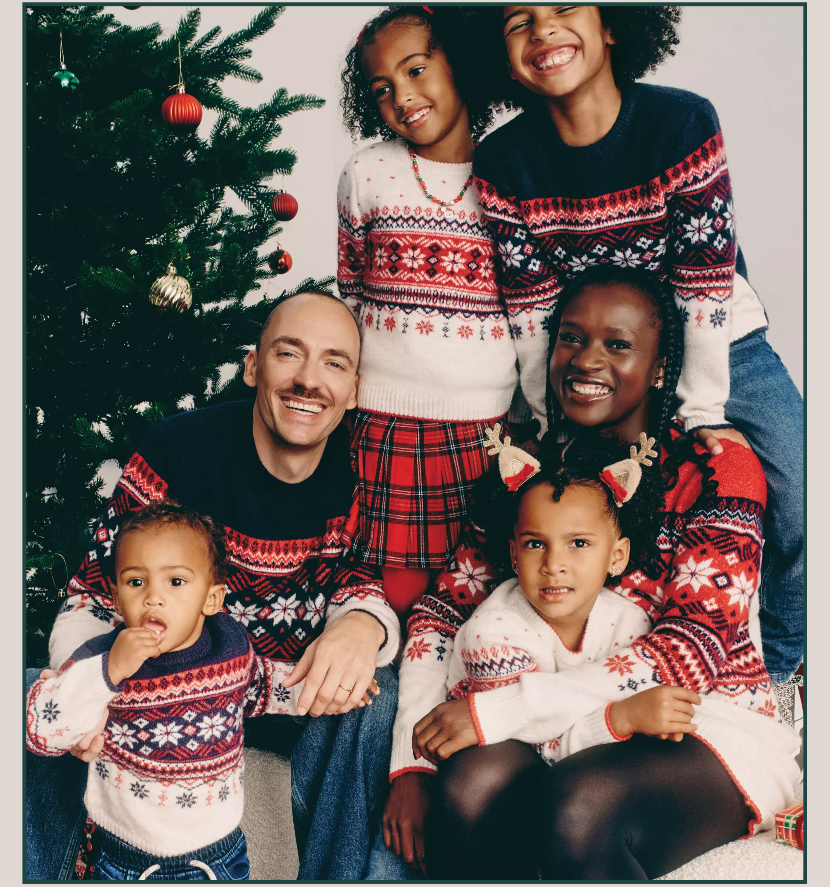 A family wearing matching navy/red fair isle jumpers 