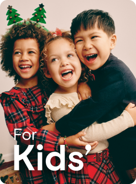 Three children smiling together wearing Christmas jumpers and accessories