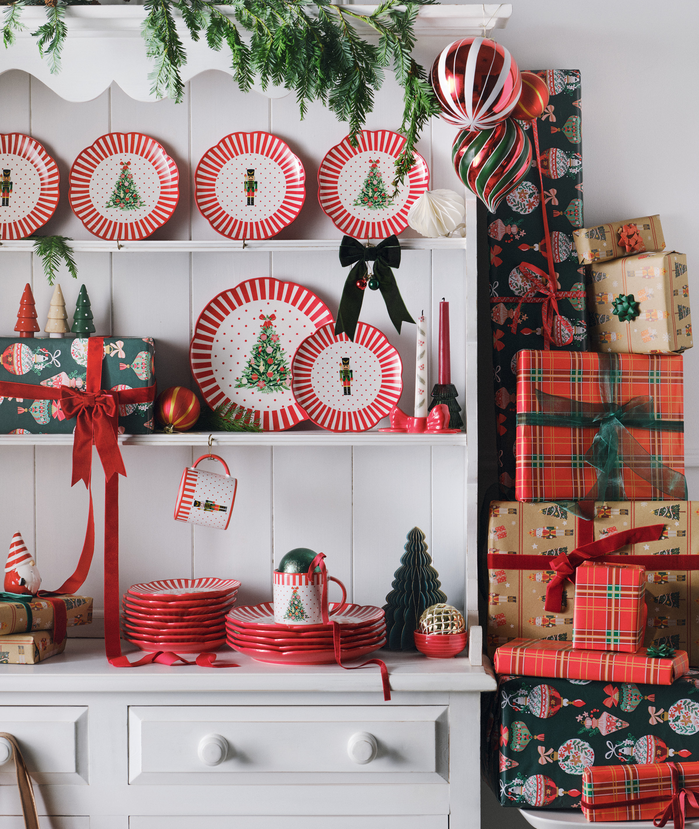 Kitchen storage covered in Christmas themed plates with wrapped presents to the right