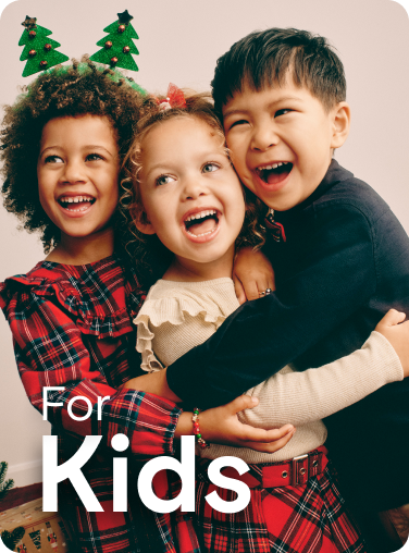 Three children smiling together wearing Christmas jumpers and accessories