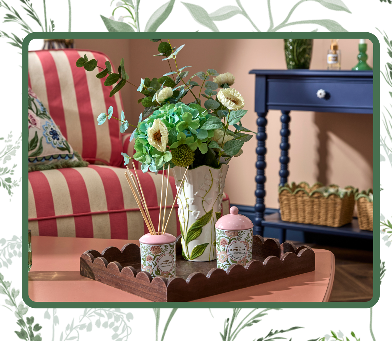 Living room with a blue side board, pink and white arm chair, table with flowers vase and candles