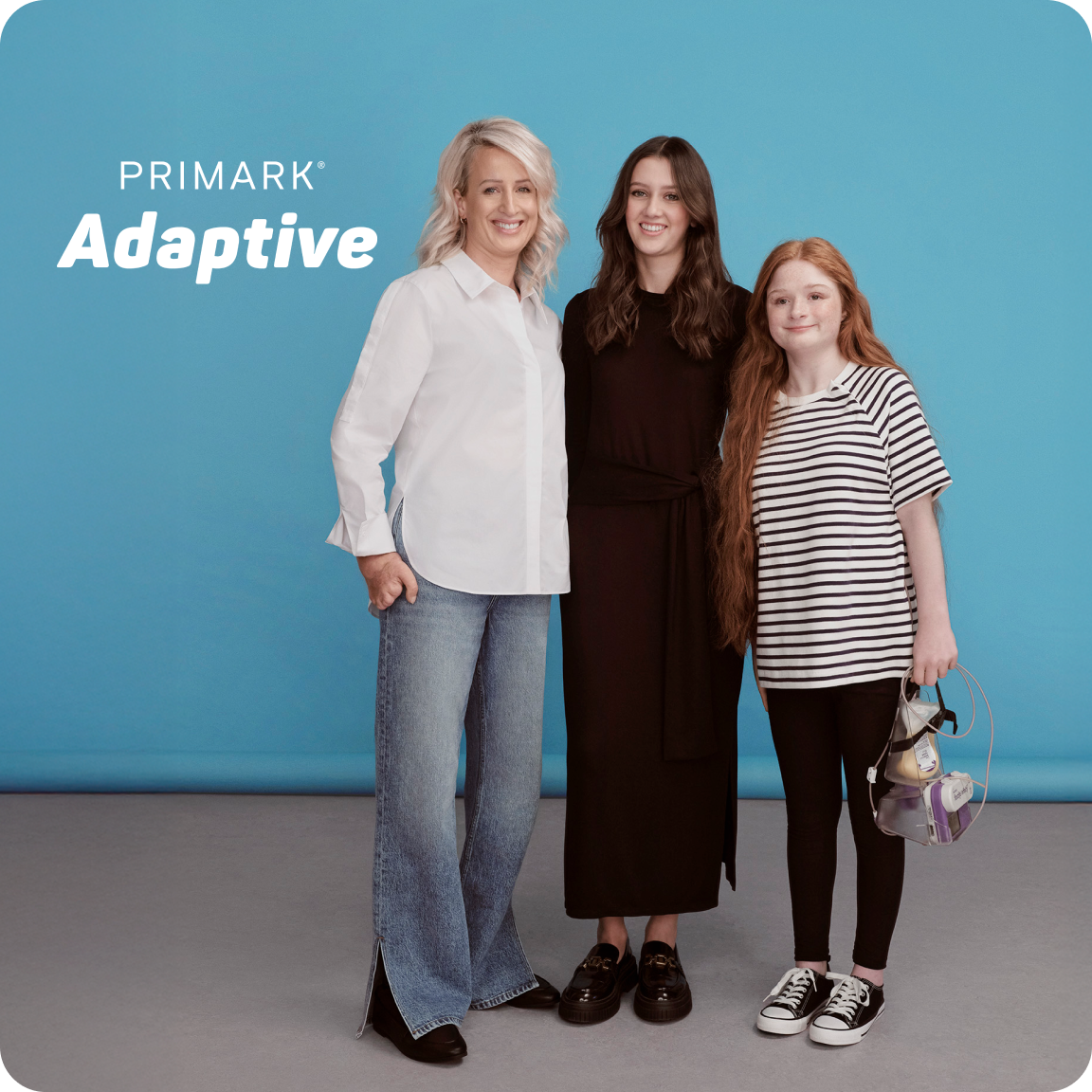 A lady wearing a white shirt with blue jeans, a lady wearing black dress and a young girl wearing a black and white shirt with black leggings