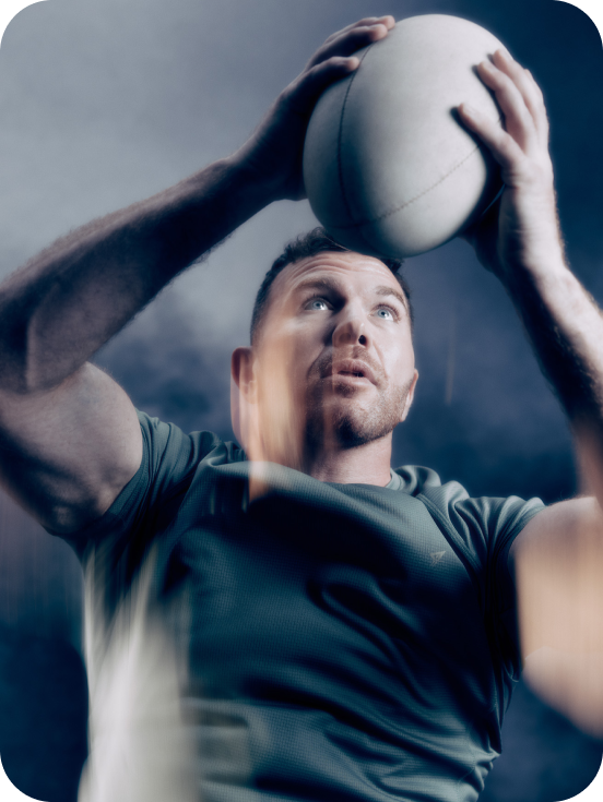 Model throwing rugby ball in the air wearing teal workout top