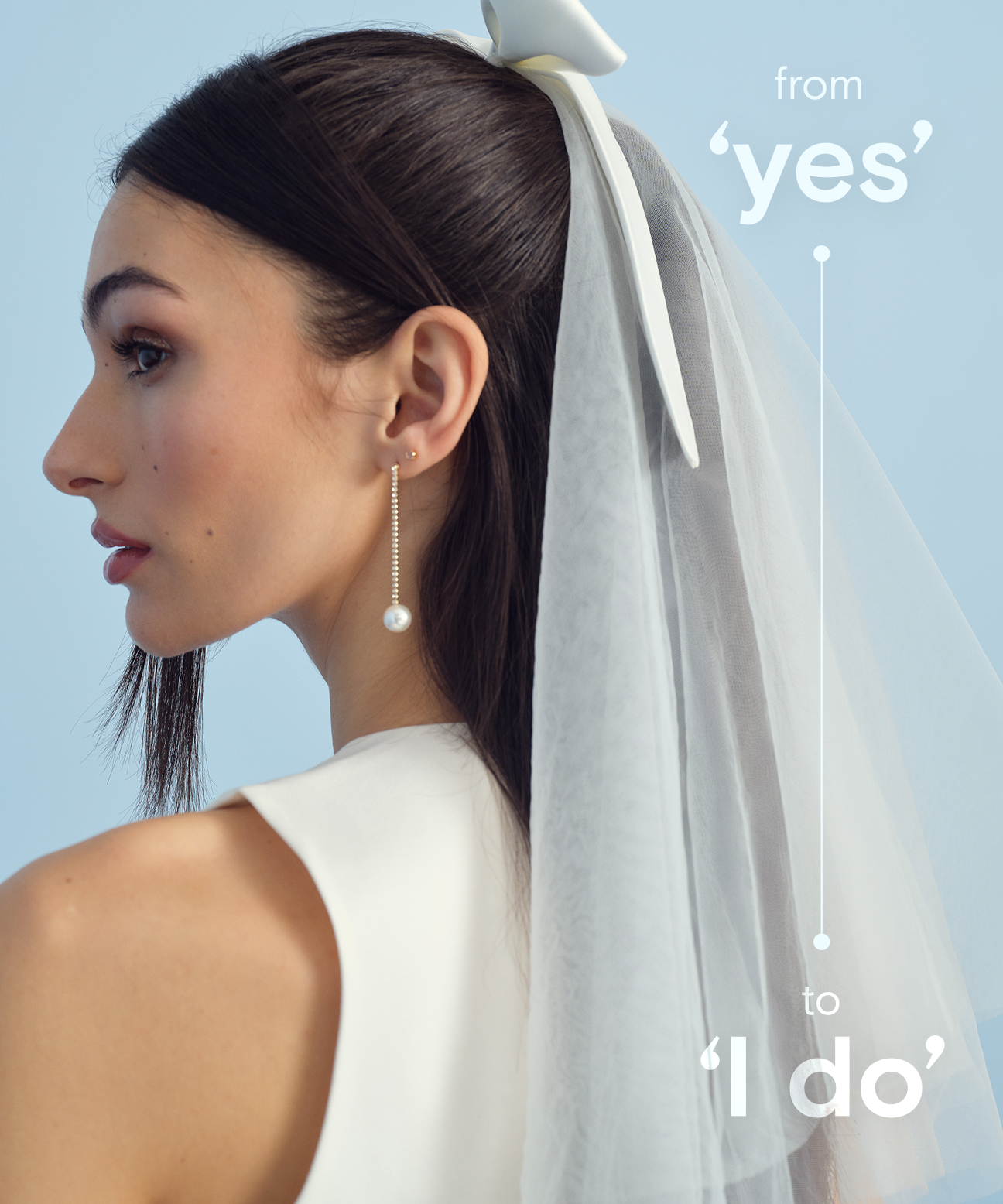 Model wearing a white veil and pearl earrings