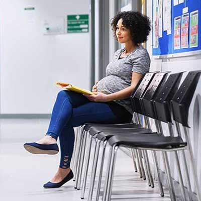 Senhora grávida em sala de espera.