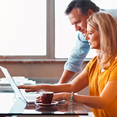 Casal a consultar informação no computador.