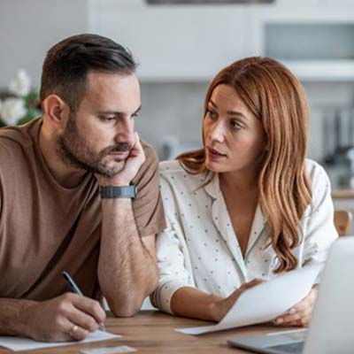 Casal calcula prestação crédito.