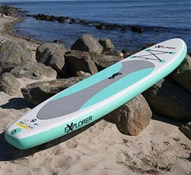 Türkis-graues SUP-Board liegt auf felsigem Ufer