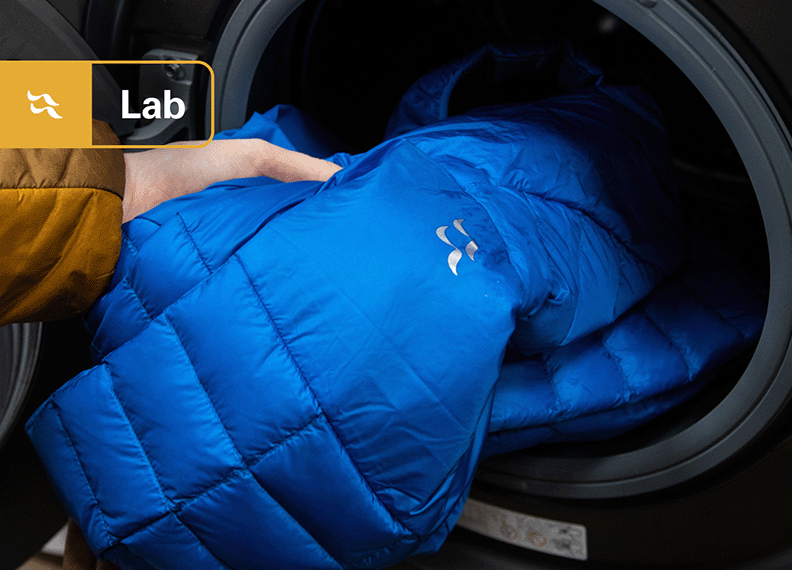 Down jacket being placed into a washing machine.