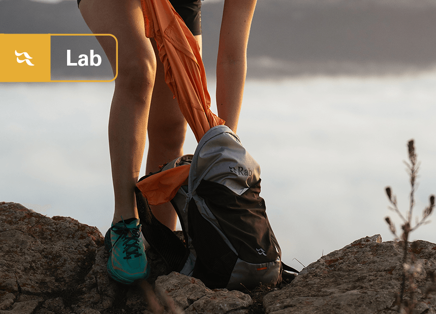 Hiker taking a midlayer out of a Rab Nitron pack.