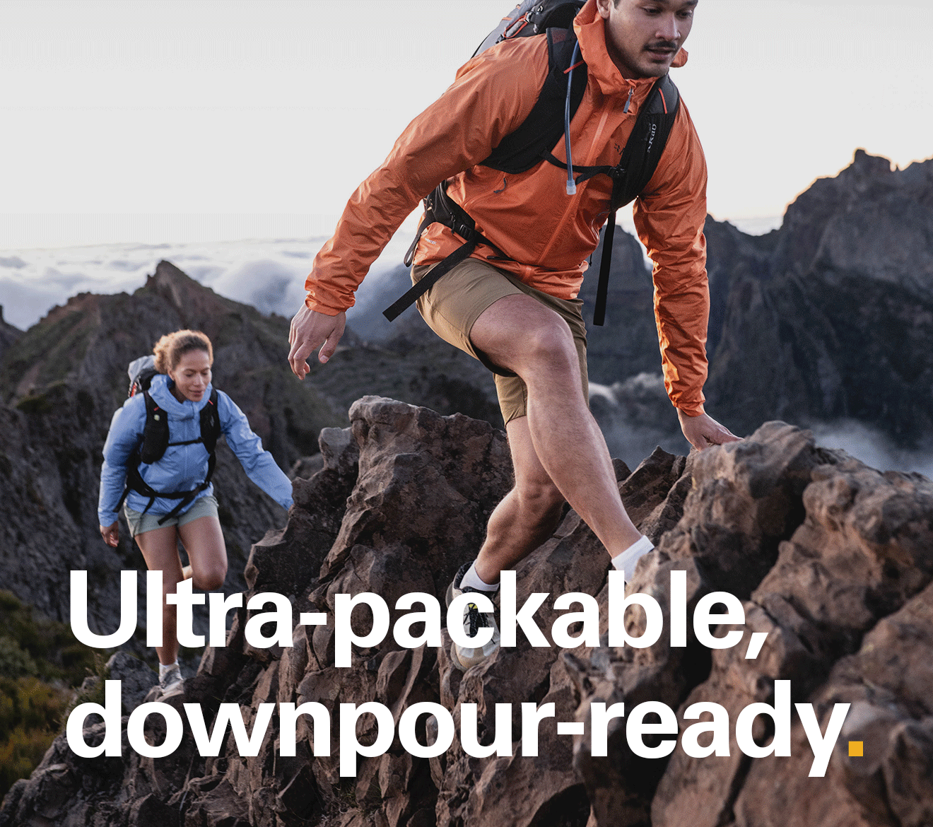 'Ultra-packable, downpour-ready.' Text over the image of a man and a woman scrabbling up a train wearing Rab jackets.