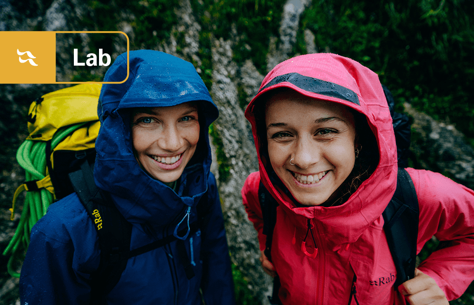 Rab Lab - Two alpinists wearing waterproofs and smiling.