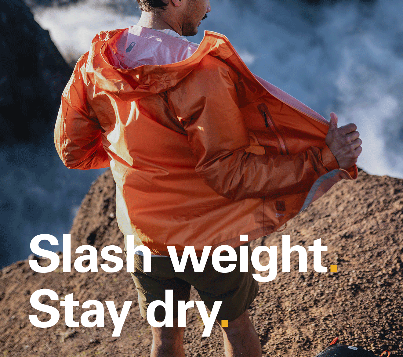 'Slash weight. Stay dry.' Text on the image of a someone at the top of a hike wearing a Rab softshell jacket.