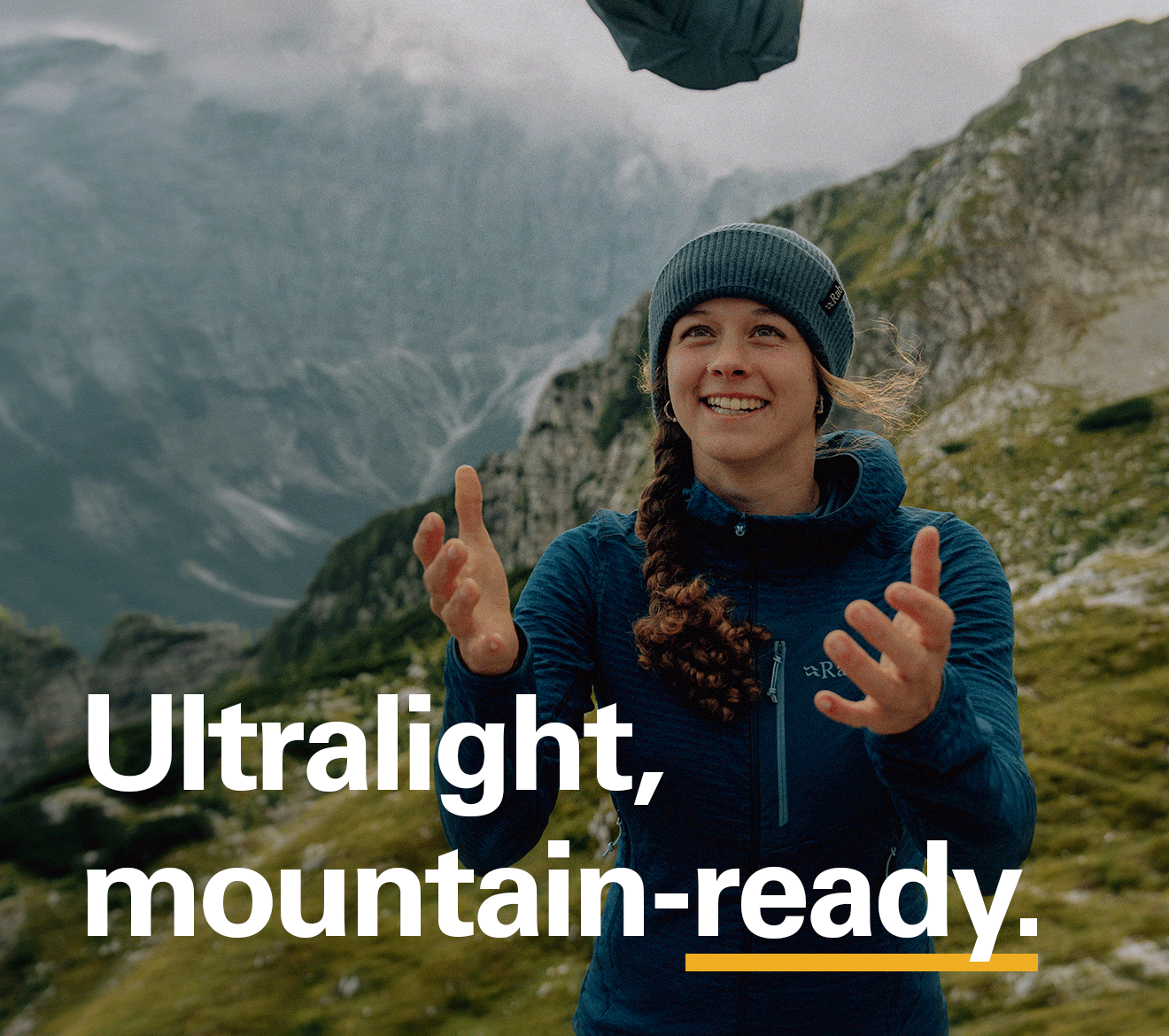 'Ultralight, mountain-ready.' Text over the image of a women catching a lightweight Rab jacket.