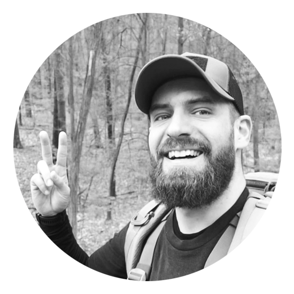Daniel D., Leiter Content-Management bei TACWRK, mit Basecap und breitem Lächeln im Wald