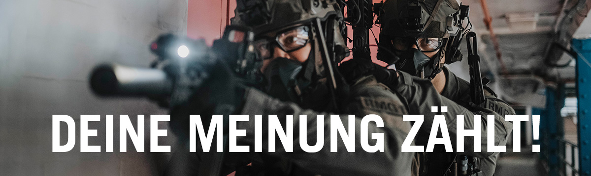 Zwei taktisch ausgerüstete Einsatzkräfte bewegen sich bewaffnet durch ein Gebäude, Fokus auf Zusammenarbeit, Ausrüstung und dynamische Einsatzsituation.