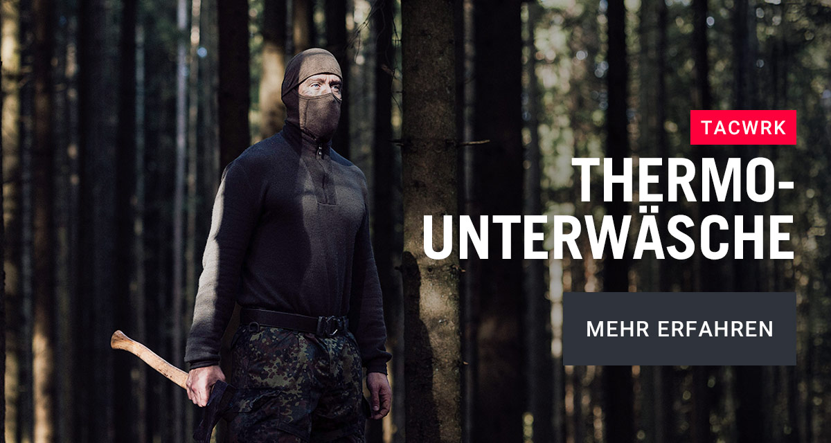 Mann in taktischer Thermo-Unterwäsche steht im Wald bei Kälte, bekleidet mit Balaclava und Funktionshose, Fokus auf isolierende Baselayer für den Einsatz bei niedrigen Temperaturen.