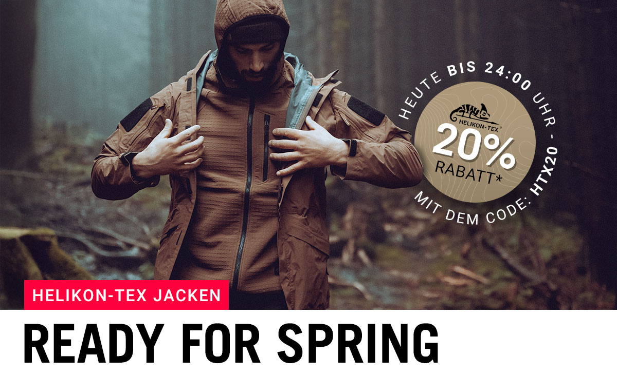 Mann trägt Helikon-Tex Outdoorjacke im Wald – 20 % Rabatt auf Helikon-Tex Jacken mit Code HTX20.