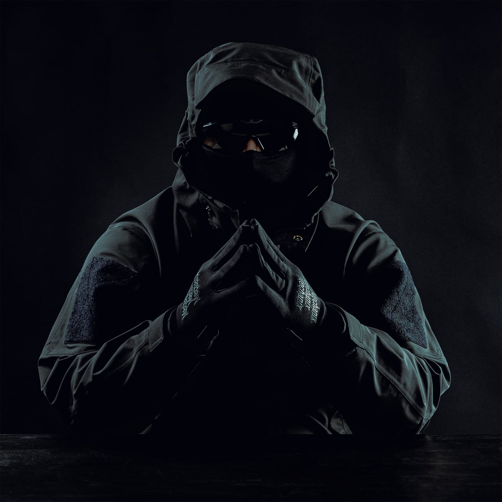 Tyyppi pukeutunut täysin mustaan mustalla taustalla