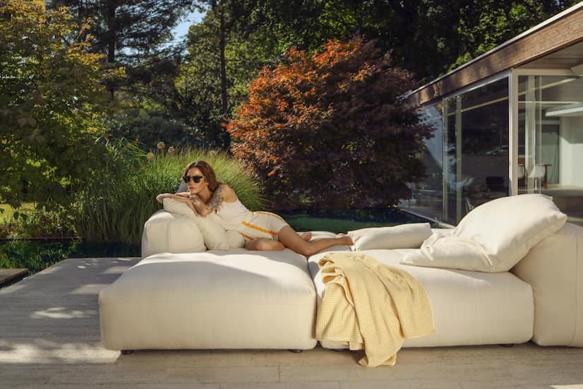 an image of a woman lounging on a vetsak outdoor sofa