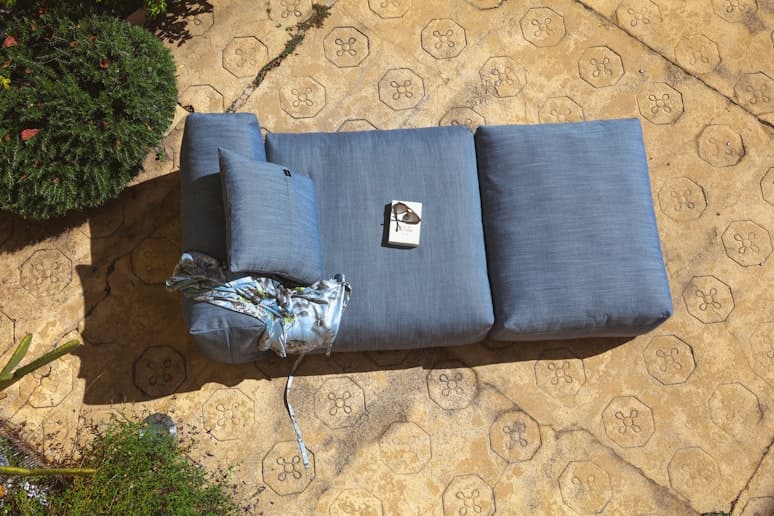 an image of a woman lounging on a vetsak outdoor sofa