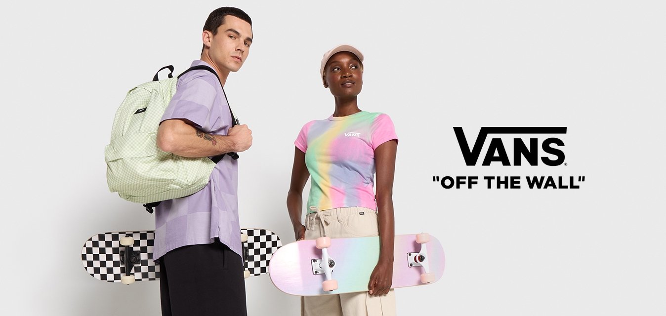 Due persone si trovano davanti a uno sfondo uniforme. Una indossa una maglietta viola a maniche corte e pantaloni neri, e tiene uno zaino a fantasia verde e un skateboard a scacchi bianco e nero. L'altra indossa una maglietta a gradiente pastello, pantaloni beigi e sneakers rosa, e tiene uno skateboard di un rosa chiaro.