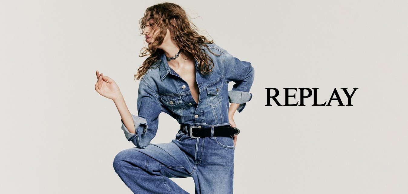 Completo in denim di un azzurro chiaro con corpetto aderente, gambe larghe e maniche lunghe. Presenta una chiusura con bottoni sul davanti e un accentato cinturino nero.