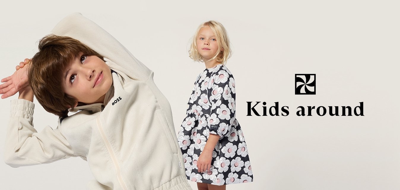 Un bambino in una giacca bianca a coste con zip e logo 