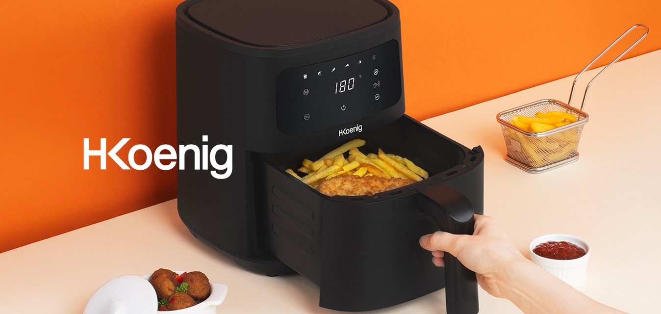 Uomo che estrae un cestello con patatine fritte e cibo impanato da una friggitrice ad aria digitale nera su un piano di lavoro beige con un muro arancione.