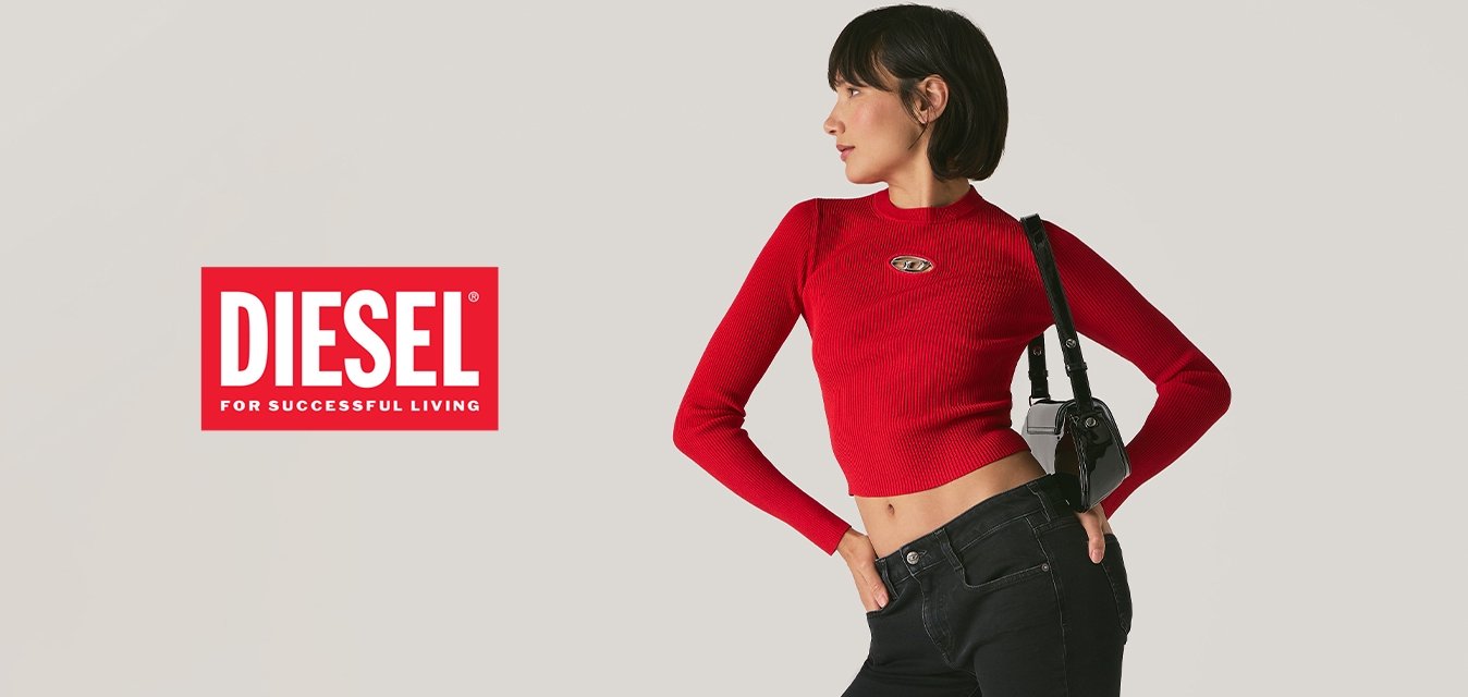 Donna in posa con jeans neri a zampa d'elefante, maglietta rossa a maniche lunghe cropped, sandali neri e una borsa a tracolla nera contro uno sfondo semplice.