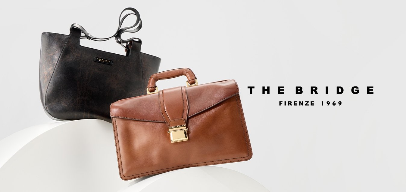 Due borse in pelle, una tote nera con spallacci e una valigetta marrone con manico e chiusura dorata, esposte su supporti bianchi curvi.