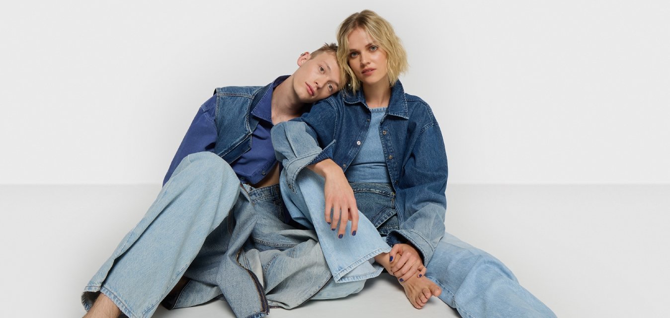 Giacca di jeans e pantaloni in azzurro chiaro, indossati con una vestibilità rilassata. Texture morbide con uno stile casual, caratterizzati da chiusura a un solo petto e gambe ampie.