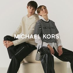 Due giovani seduti schiena contro schiena su un ottomano rotondo beige, vestiti con outfit casual chic, su uno sfondo bianco.