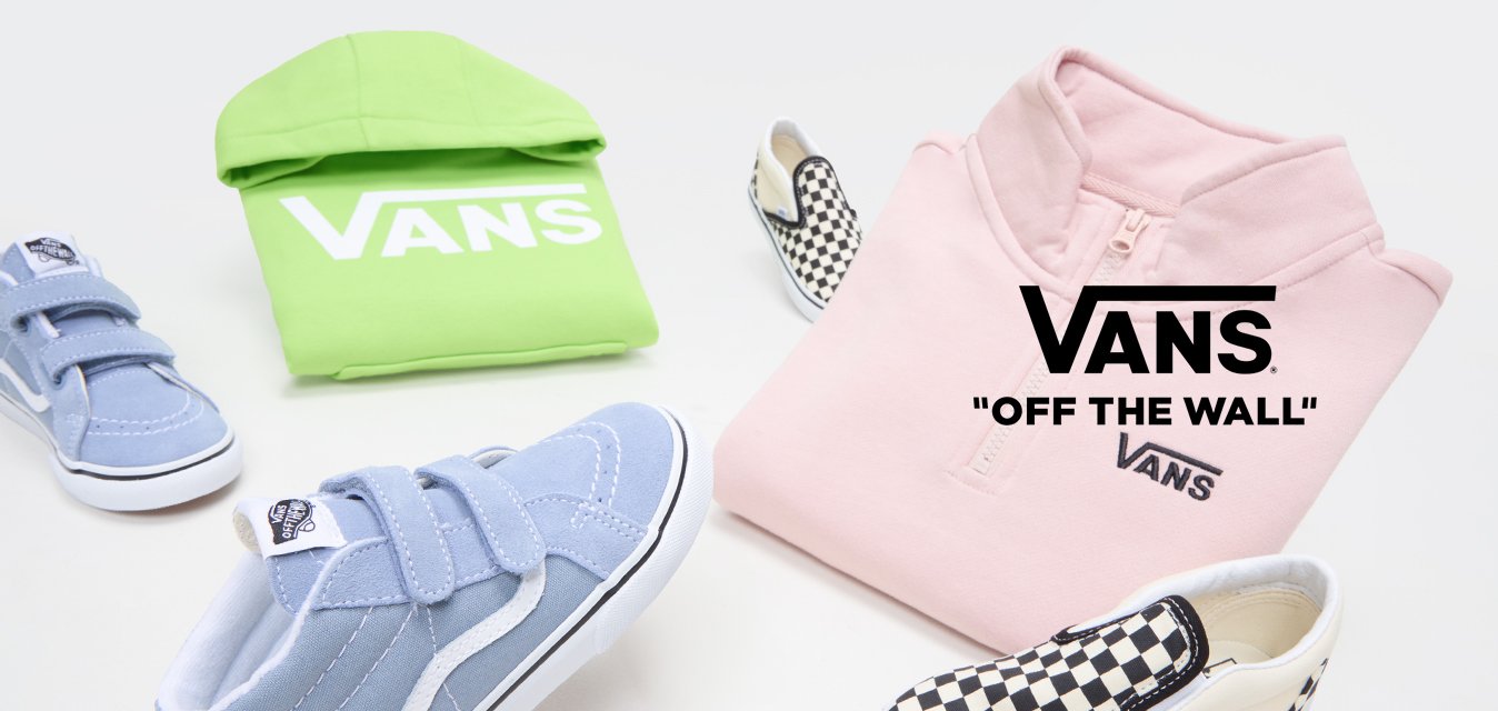 Felpa viola con zip, felpa verde con cappuccio, scarpe sportive blu con velcro e scarpe slip-on a scacchi bianchi e neri, disposte su uno sfondo bianco.