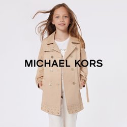 Cappotto trench beige doppiopetto con grandi bottoni, caratterizzato da un orlo con motivo. Indossato sopra una maglietta bianca e pantaloni cropped di colore chiaro.