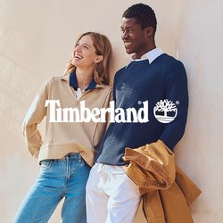 Maglione beige con zip, colletto blu; maglione blu navy a coste; jeans azzurri; scarpe marroni; pantaloni bianchi; giacca marrone; parete testurizzata; persiane verdi.