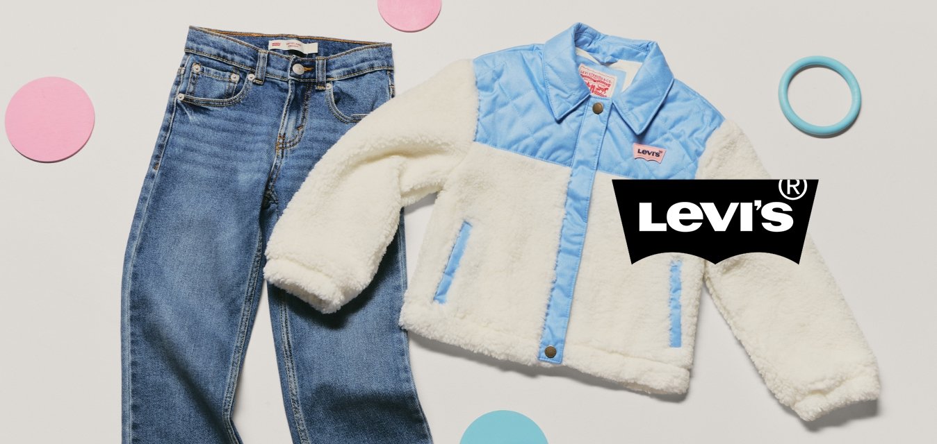 Jeans in denim blu per giovani abbinati a una giacca di pile crema e azzurro, circondati da forme circolari rosa e blu su uno sfondo bianco.