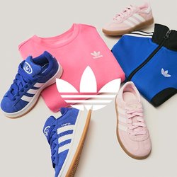 Sneaker in suede blu con strisce bianche, sneaker rosa, una felpa rosa e un giubbotto sportivo blu con accenti neri e logo.
